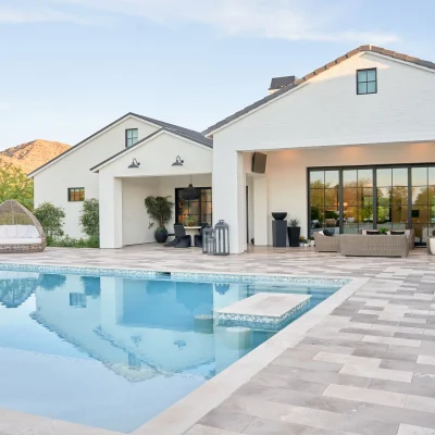 Custom home by Phoenix Home Builder McIntyre Development with travertine deck, large pool, and Mummy Mountain views.
