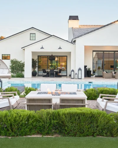 Backyard oasis by Phoenix Home Builder featuring resort-style pool and modern gas fireplace.